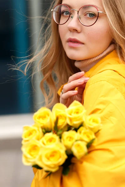 Kobieta Żółtym Płaszczu Przeciwdeszczowym Żółtymi Kwiatami Zbliżenie Jesienią — Zdjęcie stockowe