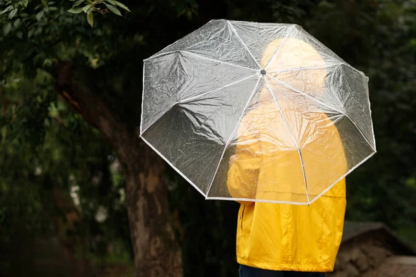 雨の中秋に傘を差した黄色いレインコートの女性が — ストック写真