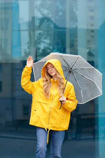 Meisje Een Gele Regenjas Met Een Paraplu Een Blauwe Achtergrond — Stockfoto