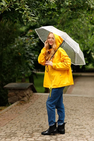 Yağmurda Şeffaf Şemsiyeli Sarı Yağmurluk Giyen Mutlu Kadın — Stok fotoğraf