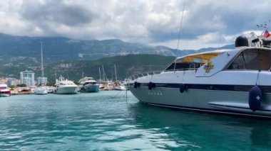 Budva limanında Amerikan bayrağı taşıyan beyaz, modern bir yat. Karadağ. 12.07.2021