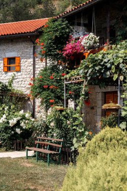 Bahçede yeşilliklerle çevrili kiremitli çatılı taş ev. yaz arkaplanı