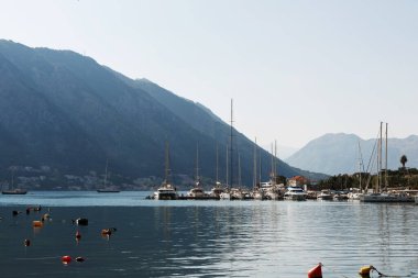 Kotor Körfezi 'ndeki dağların arka planına karşı yatlar. Karadağ 12,07,2021
