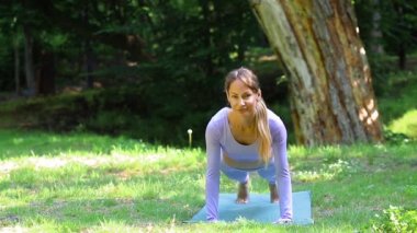 Parktaki kadın yoga yaparken minder kullanıyor. Sağlıklı bir yaşam tarzı. Kadın Sağlığı