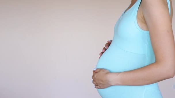 Schwangere Yogaanzug Streichelt Ihren Bauch Vor Hellem Hintergrund Schwangerschaft Und — Stockvideo