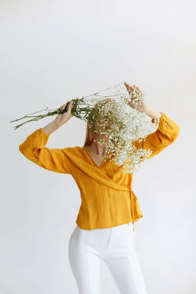 ブロンドの女の子は乾いた白い花で顔を覆います ロマンス ブロガー初秋 — ストック写真