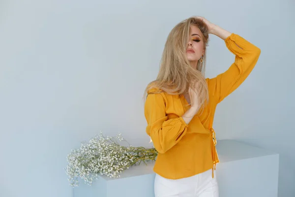 Een Blondine Een Mosterdshirt Een Modieuze Achtergrond Raakt Haar Gezonde — Stockfoto