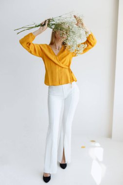 Kız yüzünü kuru çiçeklerle kaplıyor. Moda fotoğrafı. ruh hali