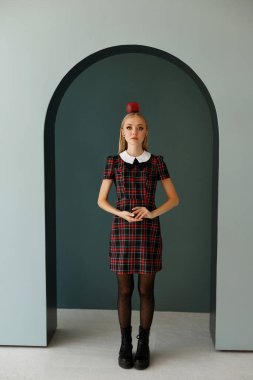 Kafesteki elbiseli bir sarışın kafasında bir elma tutuyor. Cadılar Bayramı için moda imajı