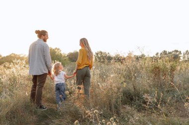 Mutlu bir aile gün batımında birlikte yürüyüşe çıkıyor. çocuk koruması