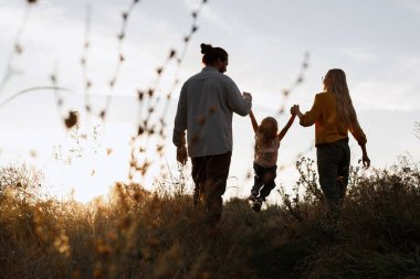 Mutlu aile akşamları gün batımında yürüyüşe çıkar.