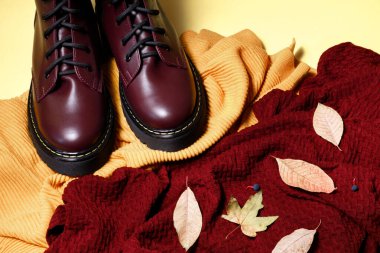 Sarı arka planda sonbahar süveteri ve botları. Sonbahar havası