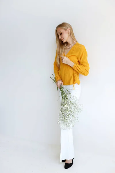 Model Blogger Een Stijlvolle Afbeelding Met Bloemen Een Grijze Achtergrond — Stockfoto