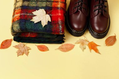 Eşarplı sonbahar arkaplanı ve ince çizmeli botlar. Metin için boş alan