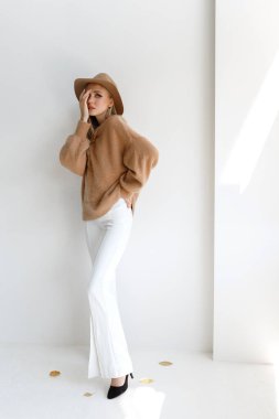 Gri arka planda sonbahar kıyafetleri giyen moda blogcusu. Alışveriş.