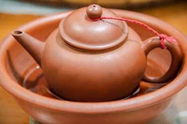 Kahverengi bir kasede geleneksel Çin çay fincanı.