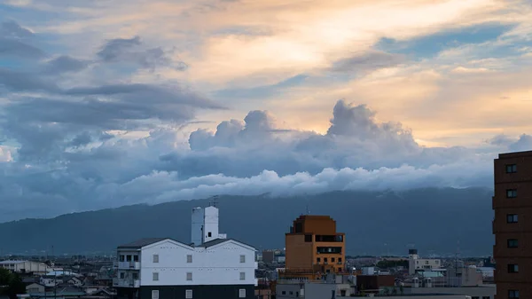 japan skyline scenery with dramatic rainy clouds and beautiful orange dawn in summer