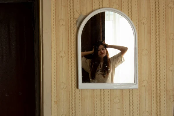Στον Καθρέφτη Που Κρέμεται Στον Τοίχο Ένα Κορίτσι Μακριά Μαλλιά — Φωτογραφία Αρχείου
