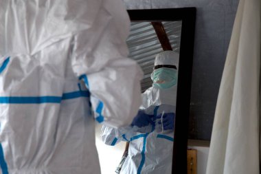 Lunsar, Sierra Leone - 29 Nisan 2015: Afrikalı sağlık çalışanı ebola salgını sırasında hazırlanıyor ve EPP koruyucu giysiler giyiyor. Salgın ve covid bağlam