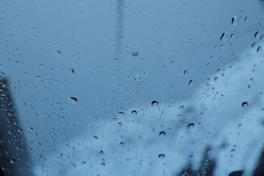 raindrops on the window with snow and snow-capped mountains in the background