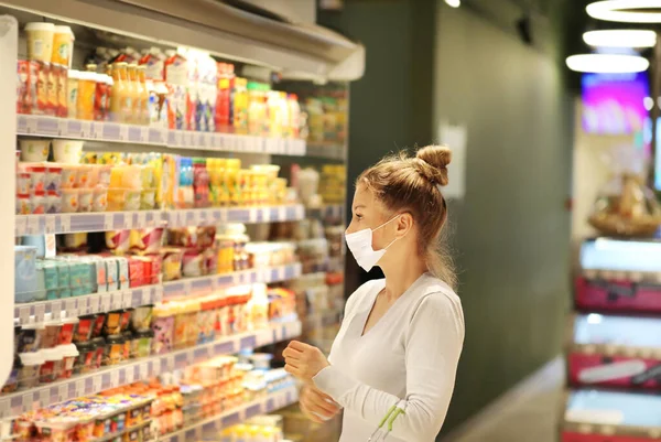 supermarket shopping, face mask and gloves,Woman choosing a dairy products at supermarket