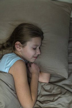 Koyu saçlı kız kahverengi yatakta uyur. yüksek kalite