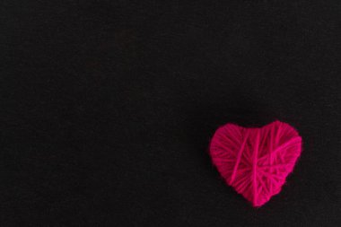 Siyah bir arka planda pembe ipliğin kalbi. Sevgililer Günü konsepti. yüksek kalite