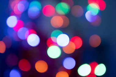 Odaklanamayan sahte ışıklar. Night City sokak lambaları arka planda. Yeni yıl çelenkleri konsepti... yüksek kalite.