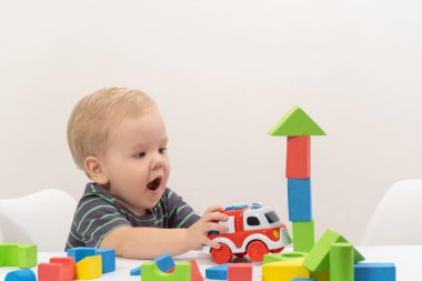 Küçük çocuk arka planda küp oynuyor.