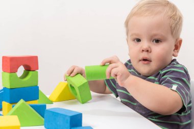 Küçük çocuk arka planda küp oynuyor.