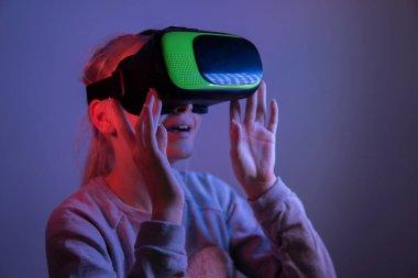 Sanal gerçeklik gözlüklü genç kız karanlık bir odada. seçici odak .