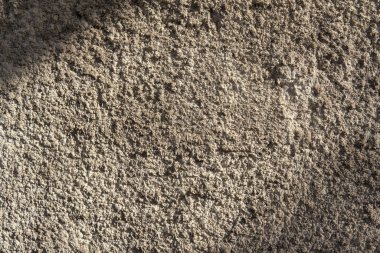 Sıcak kireçtaşı dokusu. Kaba desenli gri beton duvar