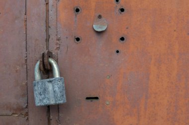Kapıda eski kilit var. Eski bir çiftlik evinin kapısına kilit vurun. Gerçek köy tarzı. Yakın plan. Kilide odaklan