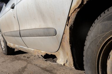 Paslı ve kirli araba kapısı aşınmadan zarar görmüş. Kapıda delik var. Arabaya karşı ihmalkar tavır. Antikorozyon tedavisi eksikliği, yol reaksiyonlarına maruz kalmanın sonuçları. Seçici odak