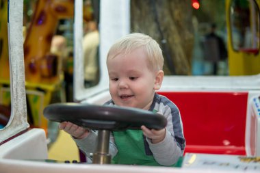 Komik küçük çocuk oyuncak araba kullanıyor.