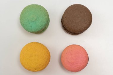 Beyaz arka planda renkli Fransız kurabiyeleri. Üst Manzara. Pastel renkler
