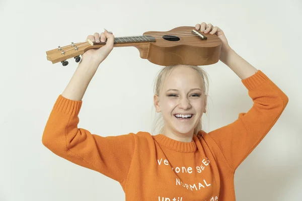 Gri Arka Planda Gitarı Olan Sarı Saçlı Genç Bir Kız — Stok fotoğraf