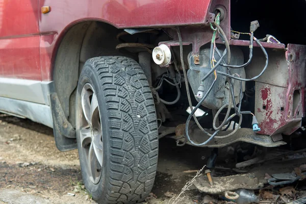 Broken expensive car after an accident in the Parking lot in the winter. A car with snow without a bumper and front lights. Car repair. Smashed in front of the car