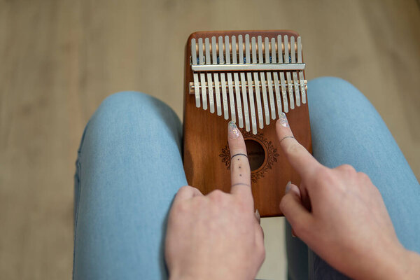 women s hands hold African calimb on light background