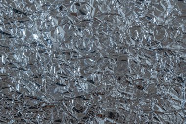Parlak buruşuk yüzeyi olan gümüş folyo arka plan doku arkaplanı