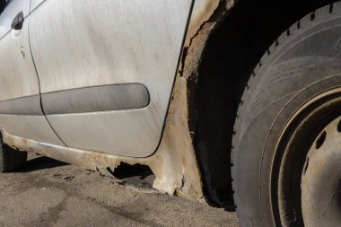 Paslı ve kirli araba kapısı aşınmadan zarar görmüş. Kapıda delik var. Arabaya karşı ihmalkar tavır. Antikorozyon tedavisi eksikliği, yol reaksiyonlarına maruz kalmanın sonuçları. Seçici odak