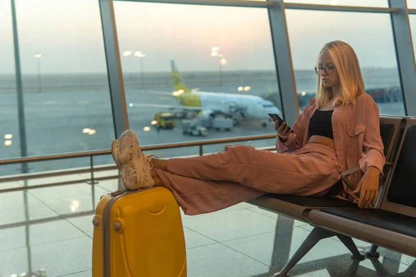 Ragazza Con Una Valigia Gialla Sedersi Aspettare Aeroporto — Foto Stock