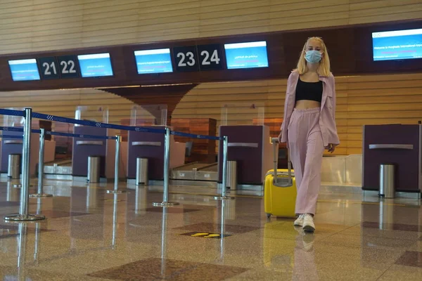 一个金发碧眼的少女走到机场的信息栏 — 图库照片