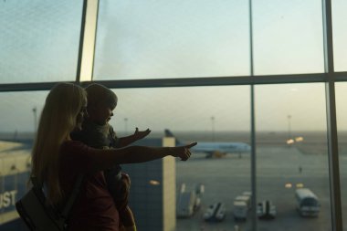 Anne ve oğlu havaalanına giden uçağa bakıyor. Bekleyen uçuş