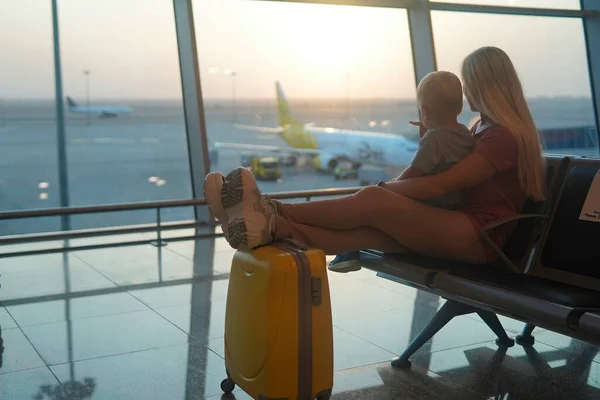 Madre Hijo Sentados Una Maleta Amarilla Aeropuerto Mirando Avión —  Fotos de Stock