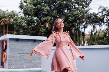 Genç, güzel, beyaz tenli, romantik bir kadın. Yazlık, şirin bir elbiseyle tatilde.