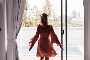 Genç, güzel, beyaz tenli, romantik bir kadın. Yazlık, şirin bir elbiseyle tatilde.