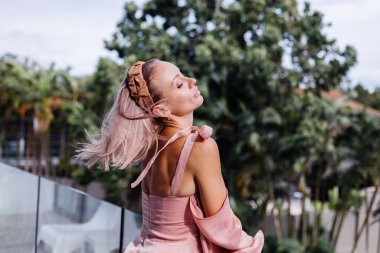 Genç, güzel, beyaz tenli, romantik bir kadın. Yazlık, şirin bir elbiseyle tatilde.