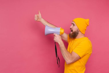 Dikkat! Avrupalı adam pembe arka planda megafonla bağırıyor