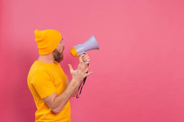 Dikkat! Megafonlu Avrupalı bir adam pembe arka planda parmağıyla işaret ediyor.